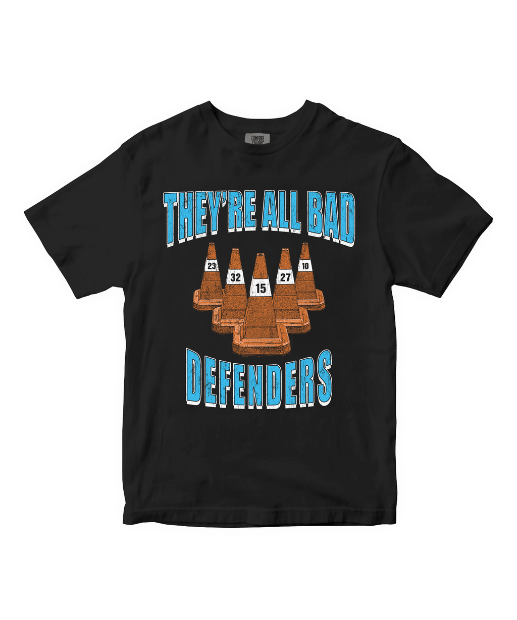 Black t-shirt with "They're all bad defenders" graphic design and text on a white background