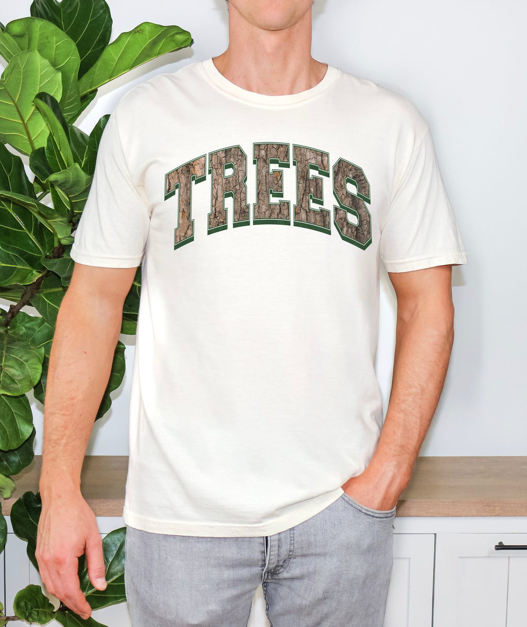 Unisex Comfort Colors t-shirt in ivory with Trees graphic design in a camo, worn by a model to display relaxed fit