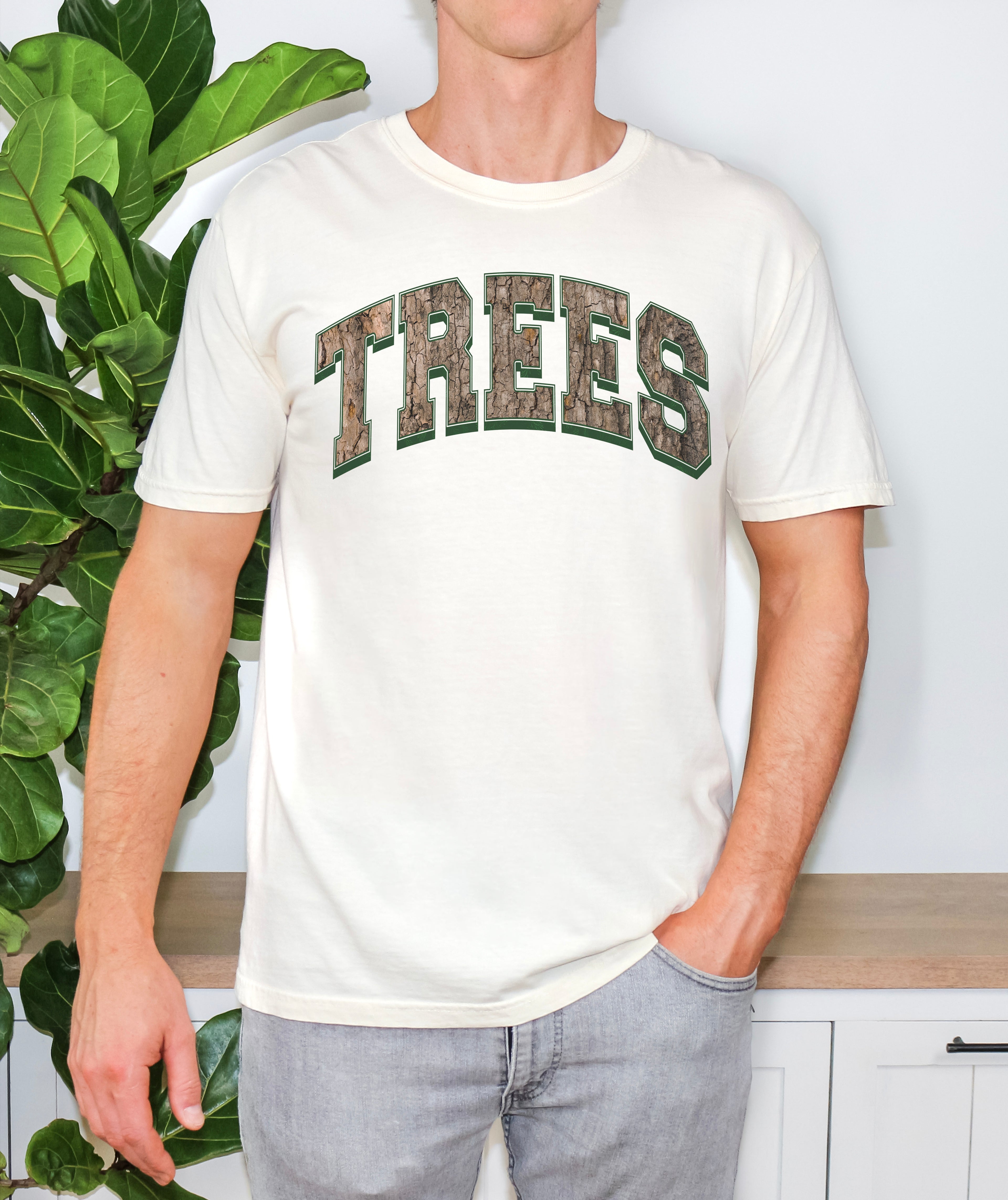 Unisex Comfort Colors t-shirt in ivory with Trees graphic design in a camo, worn by a model to display relaxed fit