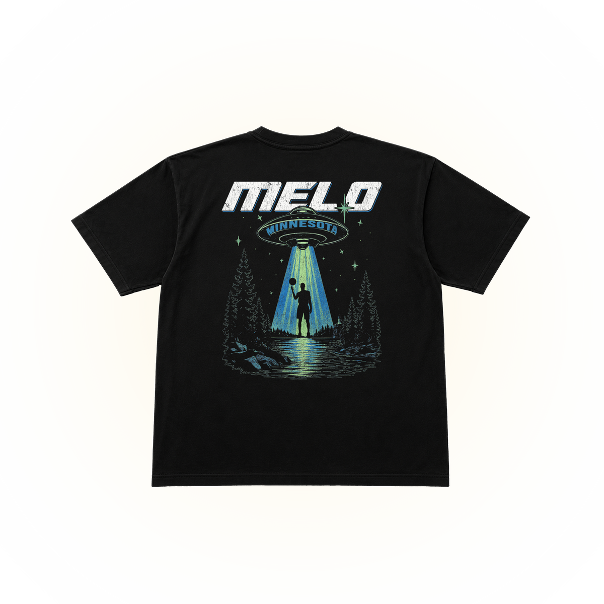 The back side of a black comfort colors tshirt featuring a large graphic print on the back. The graphic displays the text 'MELO MINNESOTA' in white and blue, above an illustration of a UFO sending a beam of light to a silhouetted figure standing in a forest by a lake.
